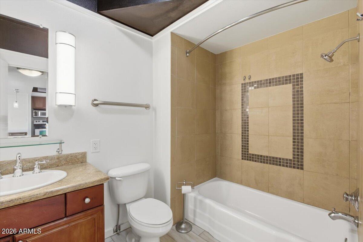 4750 North Central Avenue, Unit B14 Phoenix, AZ 85012 - Photo 17 of 57 a bathroom with a granite countertop toilet a sink and a mirror