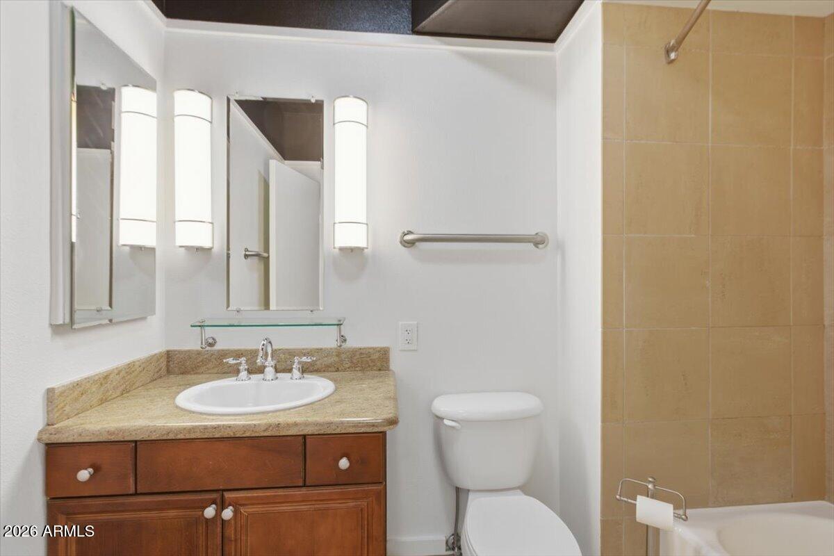 4750 North Central Avenue, Unit B14 Phoenix, AZ 85012 - Photo 18 of 57 a bathroom with a toilet sink and mirror