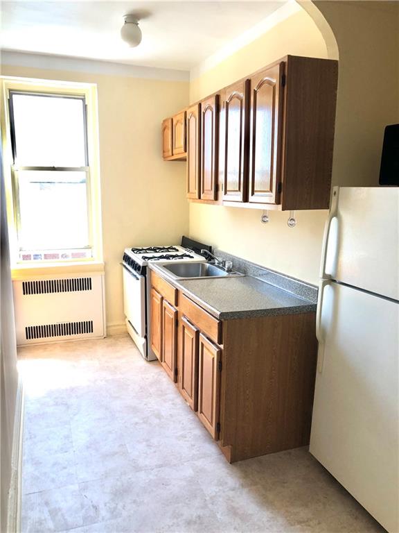 1900 Quentin Road, Unit E5 Brooklyn, NY 11229 - Photo 12 of 17 a kitchen with stainless steel appliances granite countertop a refrigerator and a stove