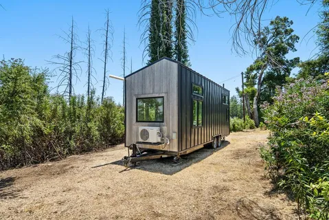 a view of a small house in the middle of a yard