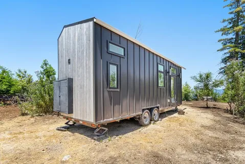 a backyard of a house with plants and trees with wooden fence