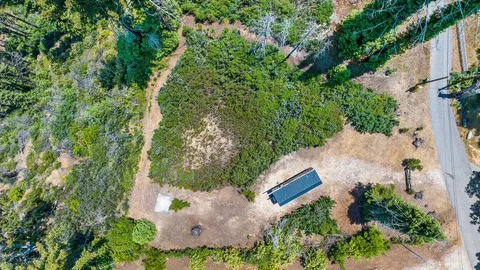 an aerial view of a house with a yard and trees