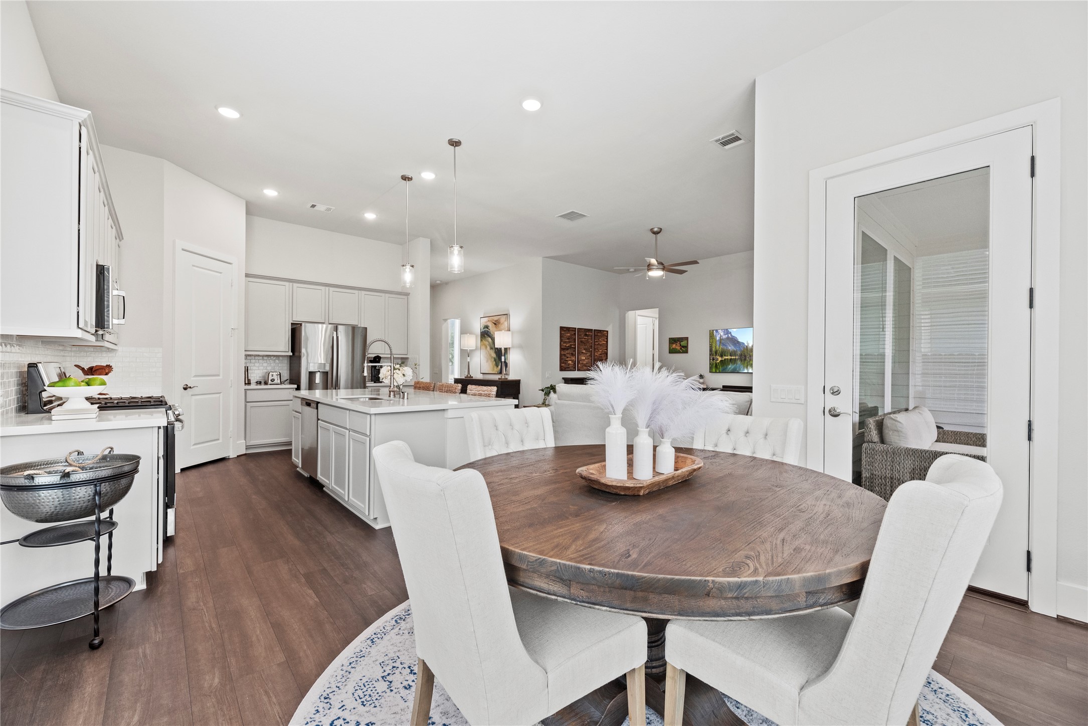 5535 Water Terrace Lane Fulshear, TX 77441 - Photo 17 of 43 a kitchen with a dining table chairs and wooden floor