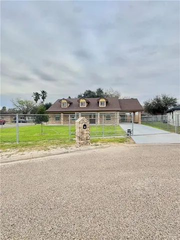 a view of a house with a big yard and large trees