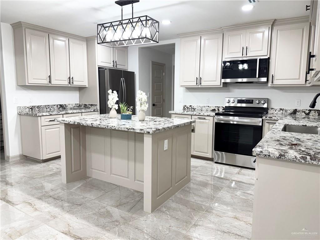 401 Stuart Court Alamo, TX 78516 - Photo 3 of 11 a kitchen with stainless steel appliances granite countertop a stove sink microwave and cabinets