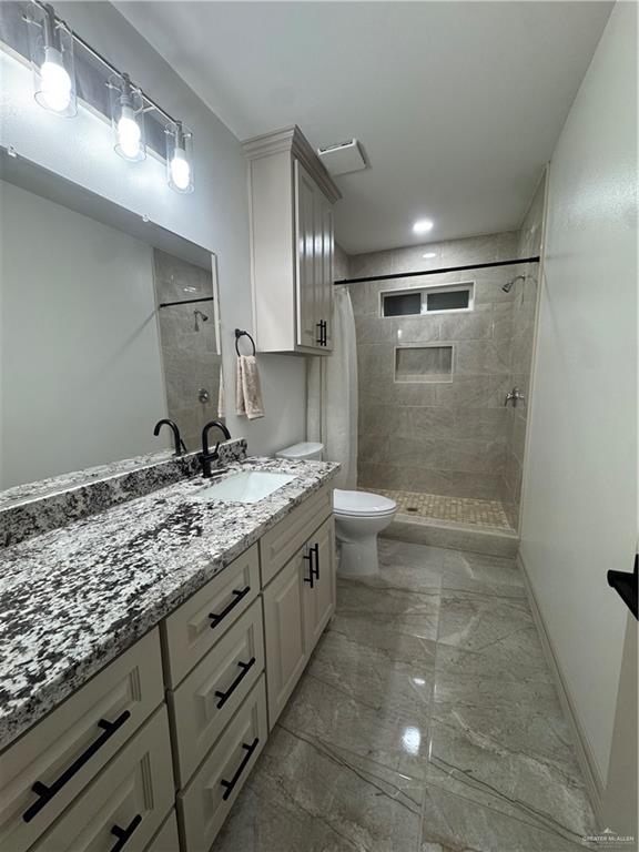 401 Stuart Court Alamo, TX 78516 - Photo 4 of 11 a bathroom with a granite countertop sink a toilet and shower