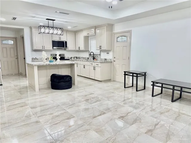a kitchen with cabinets and chairs