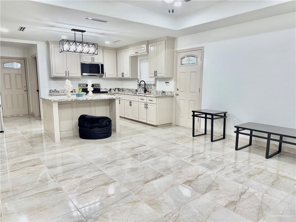 401 Stuart Court Alamo, TX 78516 - Photo 9 of 11 a kitchen with cabinets and chairs