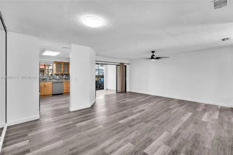 a view of a big room with wooden floor and a kitchen