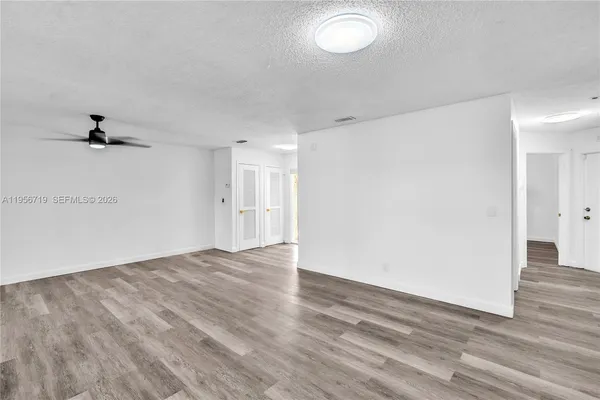 an empty room with wooden floor and windows
