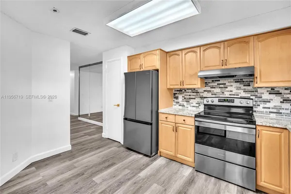 a kitchen with wooden floors and stainless steel appliances