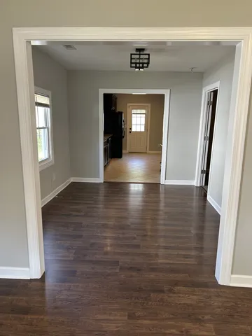 a view of a hallway with wooden floor and closet