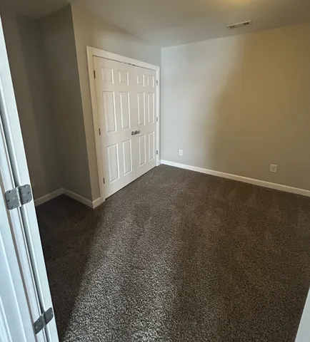 an empty room with wooden floor and mirror