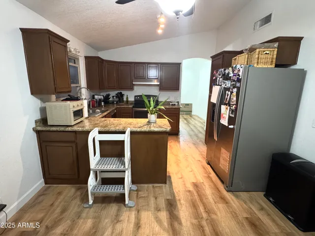 a room with stainless steel appliances furniture a flat screen tv and entryway