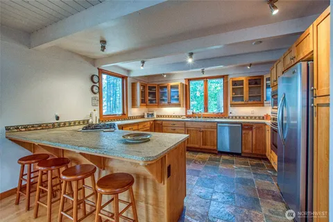 a kitchen with stainless steel appliances granite countertop a refrigerator and a sink