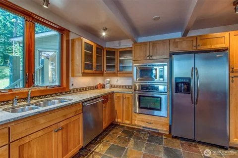 a kitchen with stainless steel appliances granite countertop a stove a sink and a refrigerator