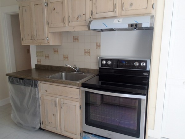 139 Winter Street, Unit 1 Framingham, MA 01702 - Photo 2 of 11 a kitchen with granite countertop white cabinets and stainless steel appliances