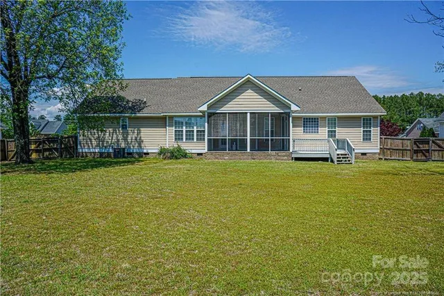 a front view of a house with a garden and trees