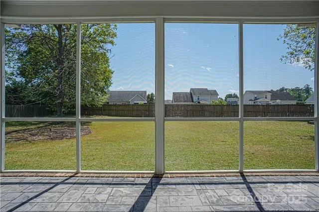 a view of a hallway with wooden floor and a bathroom