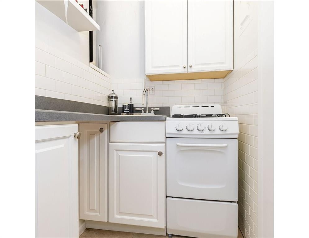 41 Jane Street, Unit 5B Manhattan, NY 10014 - Photo 6 of 8 a stove top oven sitting inside of a kitchen