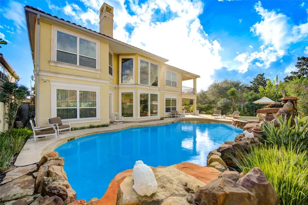 a view of a house with pool and chairs