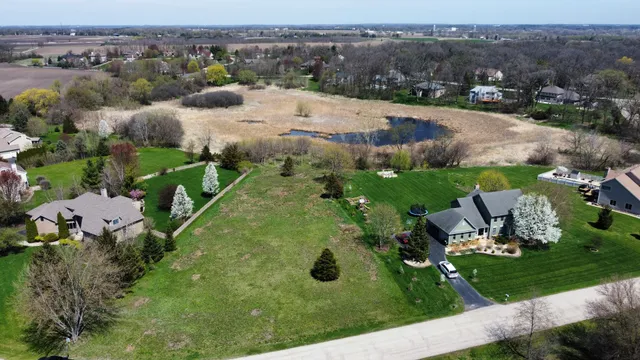 an aerial view of residential houses with outdoor space and trees