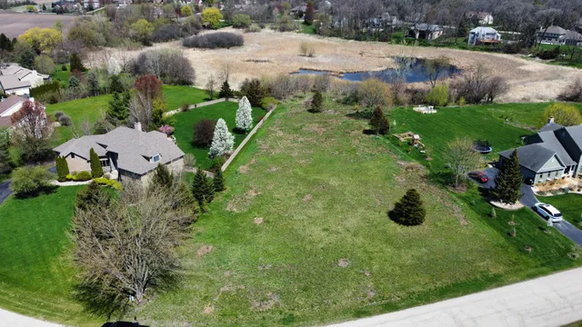 an aerial view of residential houses with outdoor space and parking