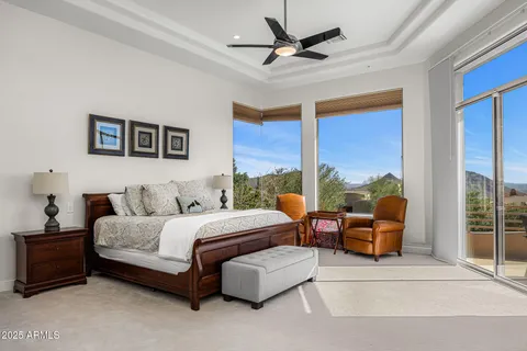 a spacious bedroom with a bed couch and a large window