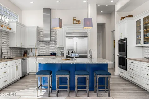 a kitchen with stainless steel appliances kitchen island granite countertop a sink and cabinets