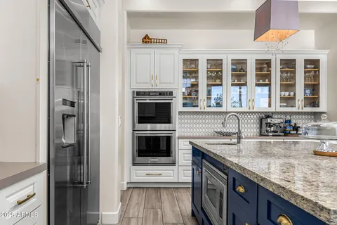 a kitchen with granite countertop a sink stove and refrigerator