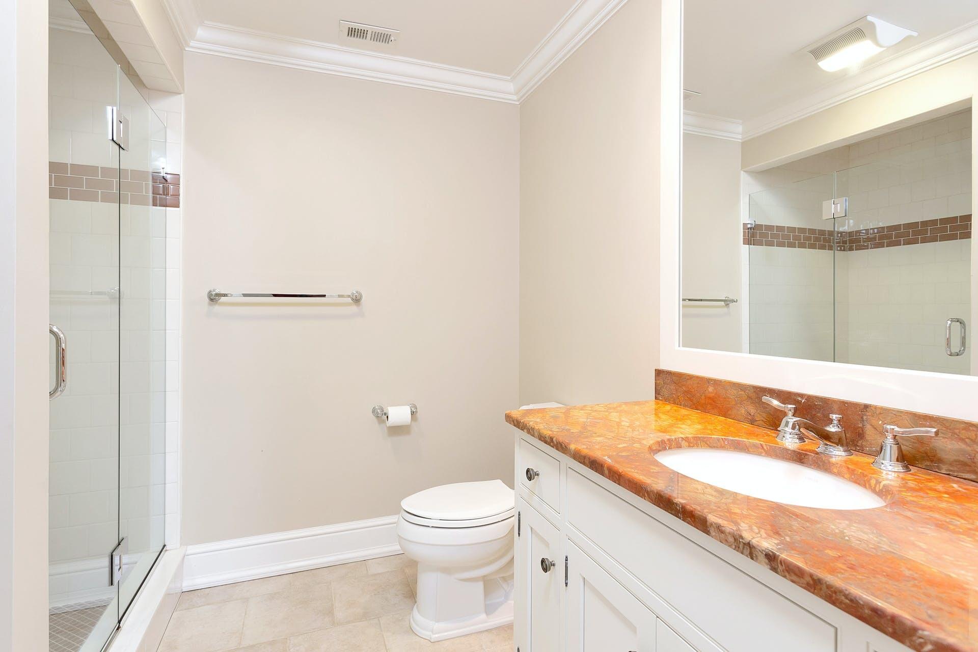 274 Mariomi Road New Canaan, CT 06840 - Photo 36 of 56 a bathroom with a granite countertop sink a toilet and shower