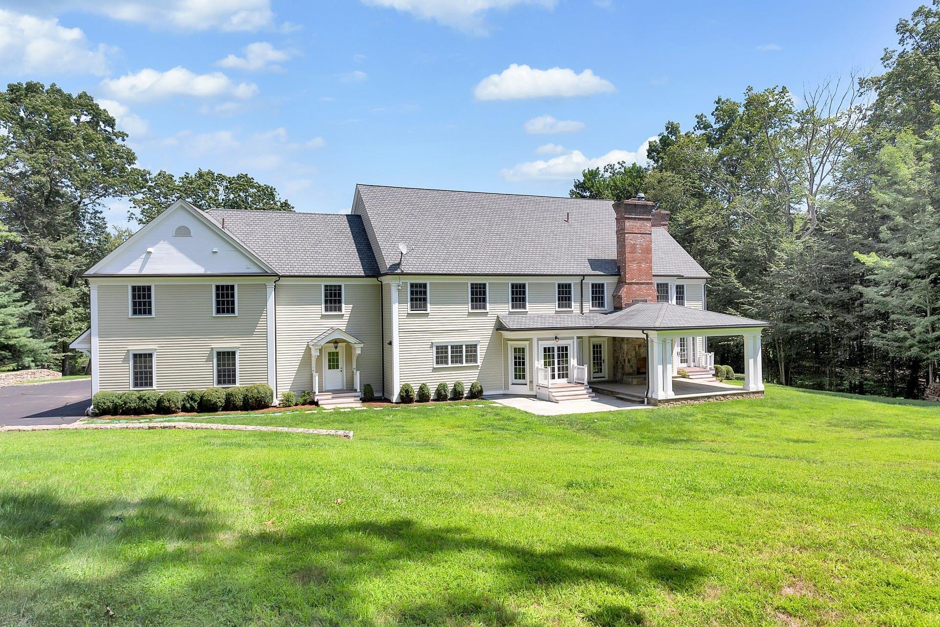 274 Mariomi Road New Canaan, CT 06840 - Photo 51 of 56 a front view of a house with a yard and trees