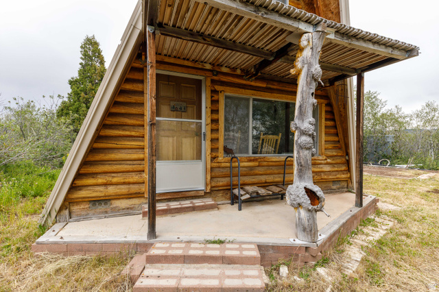 23 Scare Canyon, Unit 23 Logan, UT 84321 - Photo 5 of 33 A-frame log exterior featuring a covered porch with a unique wooden support column
