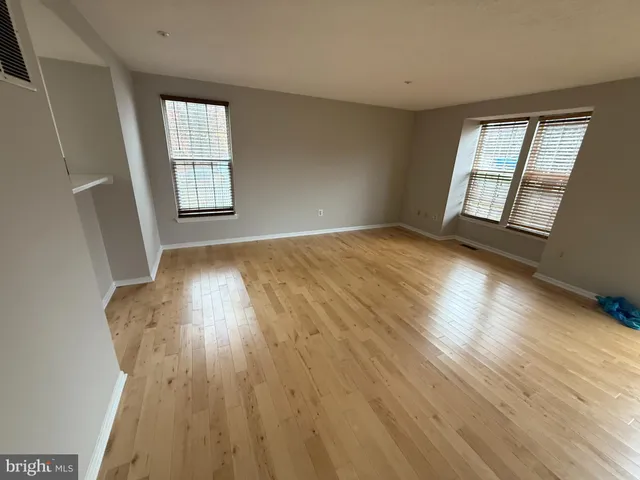 wooden floor in an empty room with a window