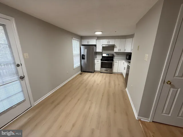 a view of kitchen with wooden floor electronic appliances and window
