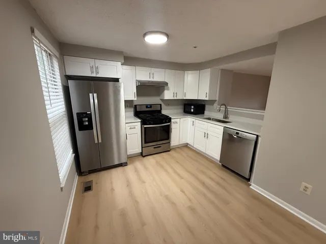 a kitchen with stainless steel appliances a refrigerator sink and microwave