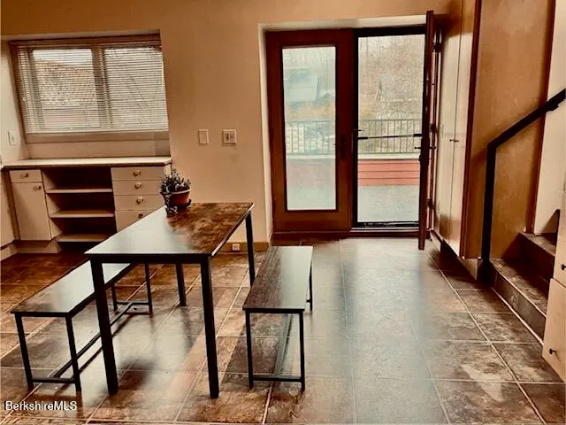 a view of a workspace with furniture and a window