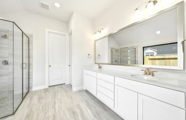 a spacious bathroom with a double vanity sink mirror and shower