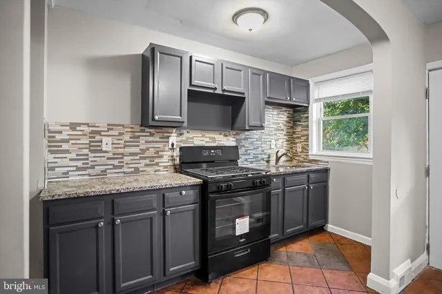 a kitchen with stainless steel appliances granite countertop a stove sink and cabinets