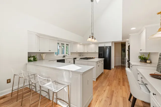 a large kitchen with kitchen island a large counter space a sink appliances and cabinets