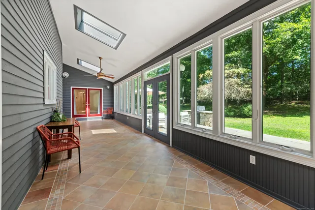a living room with furniture a flat screen tv and a large window