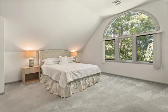 a view of a house with a yard and large trees