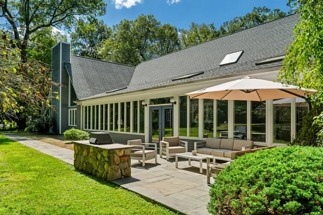 a view of a house with backyard and sitting area