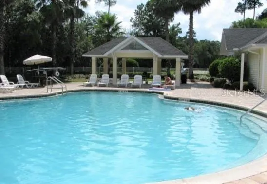 a front view of a house with swimming pool having outdoor seating