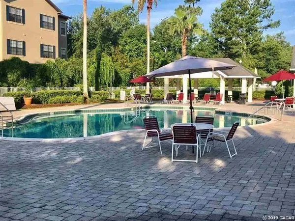 a view of a table and chairs under an umbrella in backyard