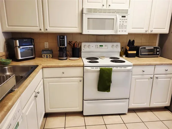 a kitchen with a sink a stove and cabinets