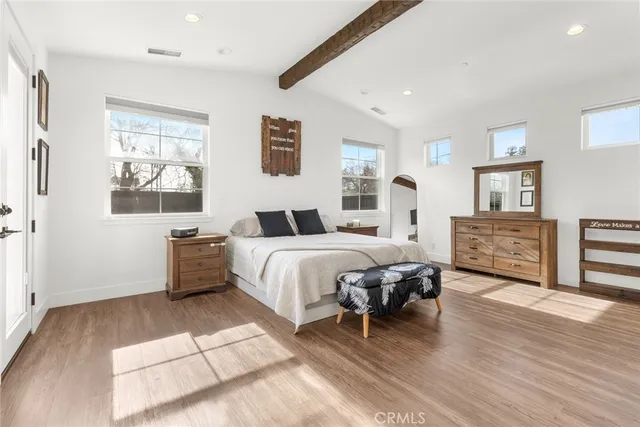 a spacious bedroom with a bed and a dresser