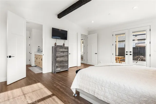 a spacious bedroom with a bed and a flat screen tv