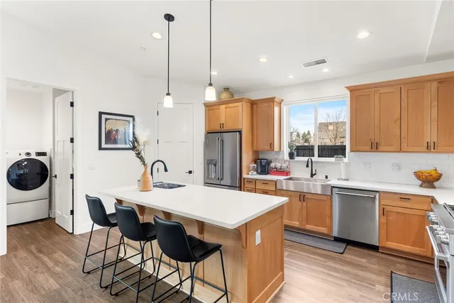 a kitchen with a dining table chairs sink and stove top oven