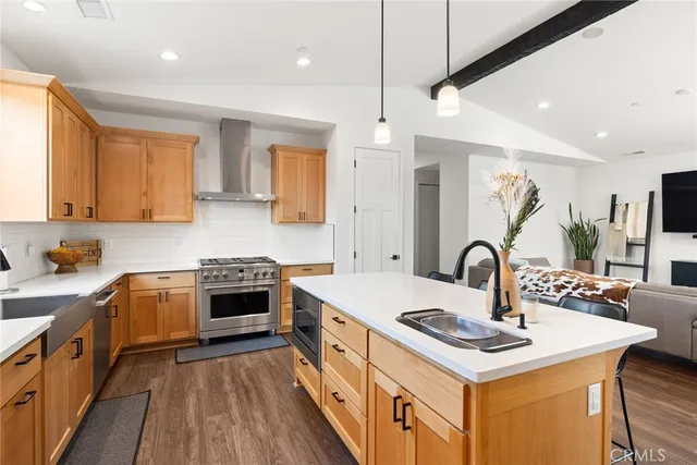 a kitchen with a white stove a sink dishwasher a kitchen island with wooden cabinets and floor